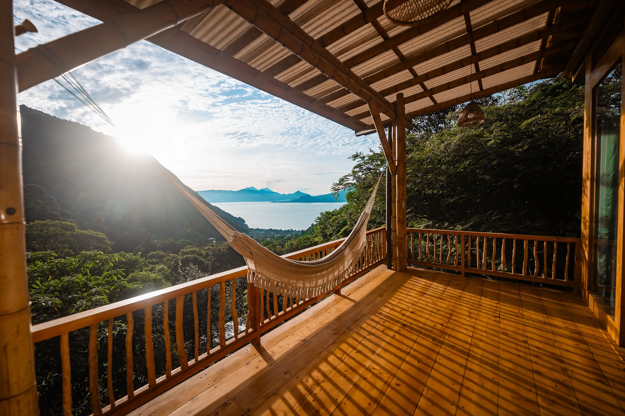 A finished terrace at WuWei Village, with a hammock looking out across Lake Atitlán to the volcanoes in afternoon light.